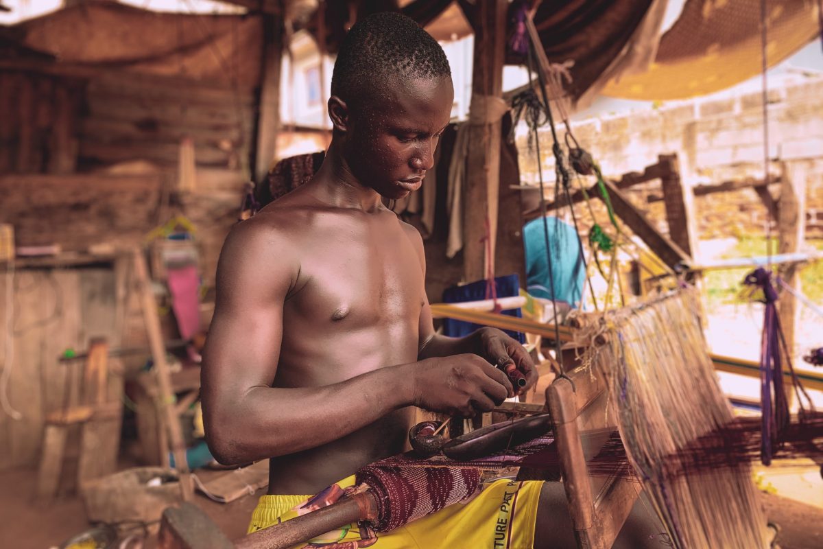 man-in-yellow-shorts-sitting-on-brown-wooden-chair-weaving-3592348