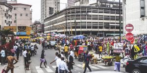 Lagos Island's commercial district, businessmen and market people crossing the street.